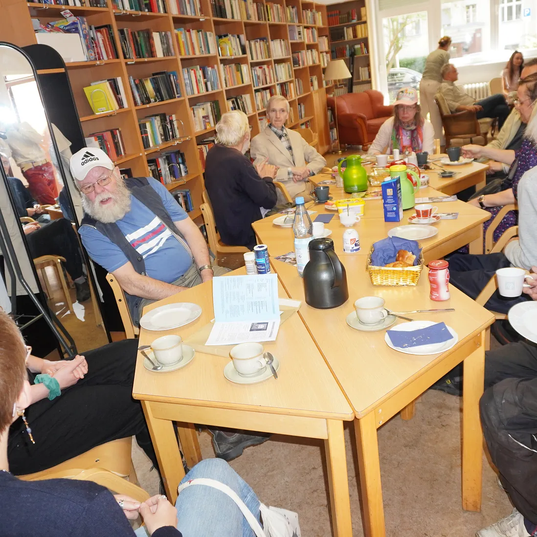 Menschen sitzen am Tisch, trinken und essen.