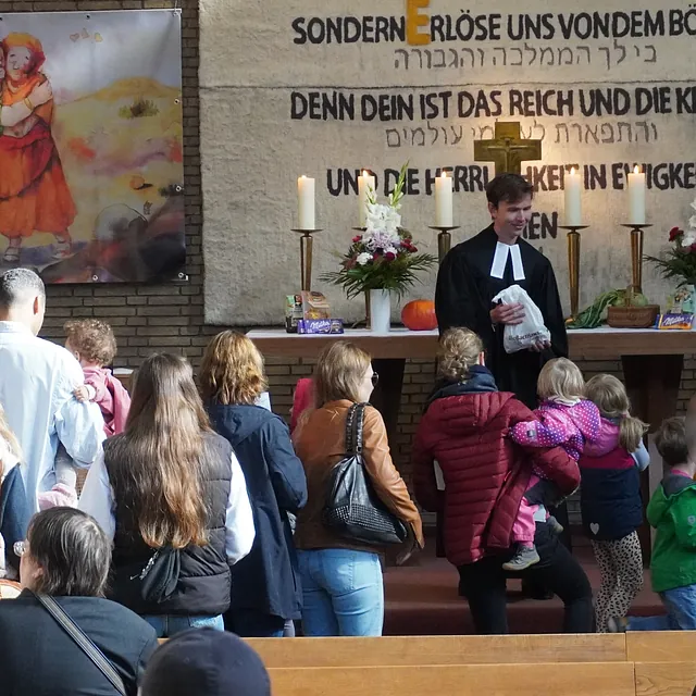 Erwachsene und Kinder laufen mit Obst zum Altar.
